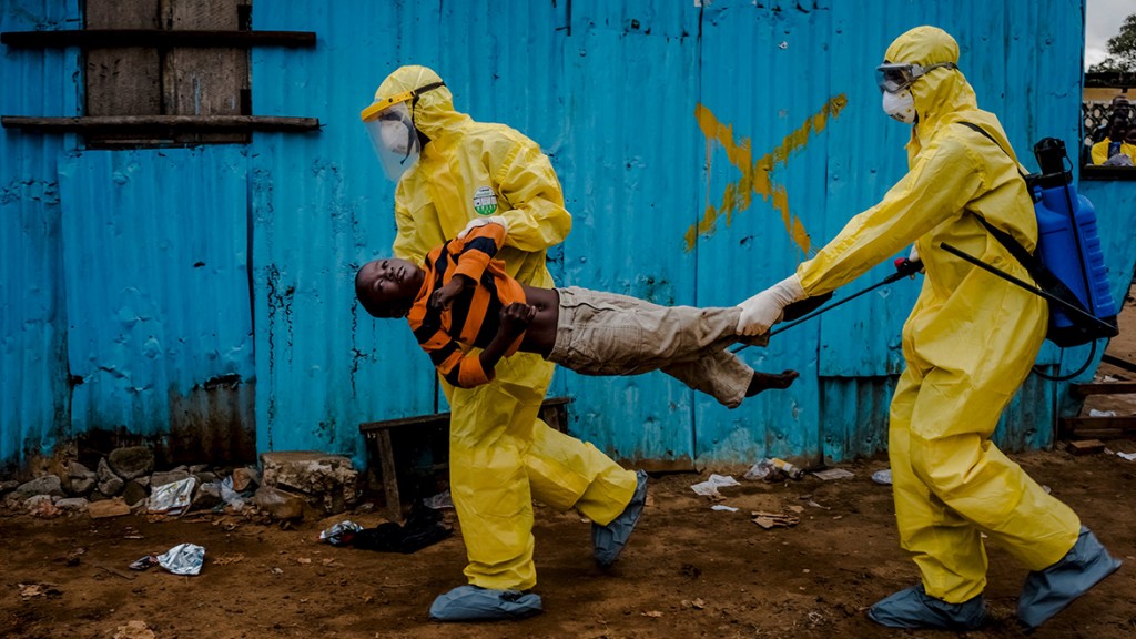 Medical staff carry James Dorbor, 8, suspected of having Ebola, into a treatment facility in Monrovia, Liberia.