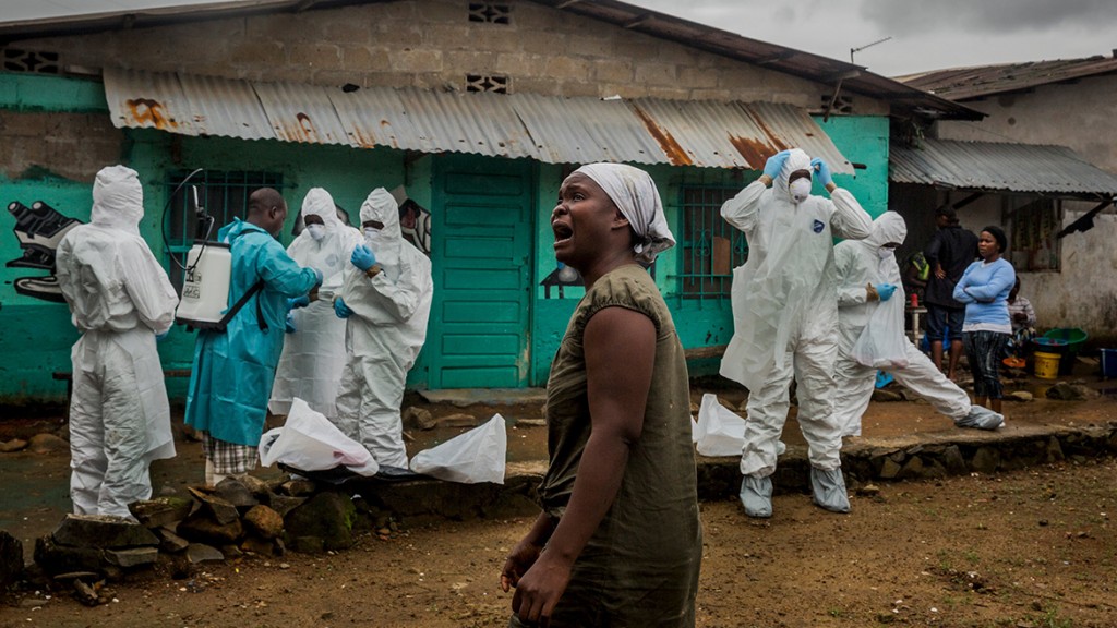 A relative grieves as a Red Cross burial team prepares to remove the body of Ofori Gweah, who died of Ebola‚Äôs telltale symptoms, in a riverside area called Rock Spring Valley in central Monrovia, Liberia.