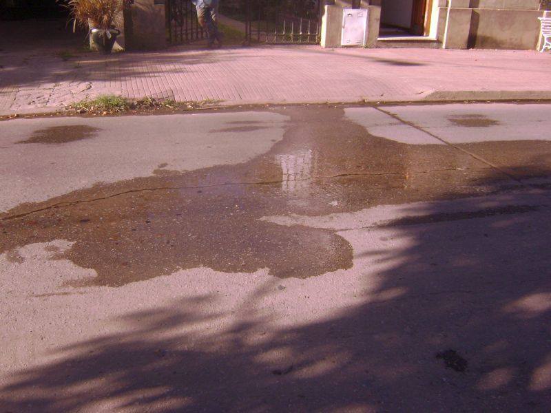 El agua de la pérdida moja el pavimento y sigue junto a los cordones.